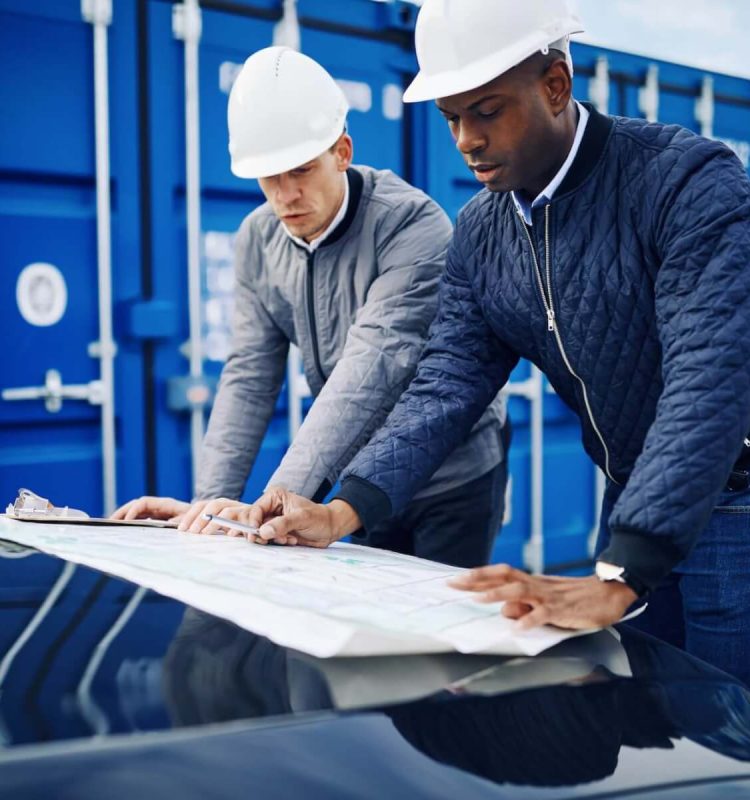 two-engineers-discussing-building-plans-together-in-a-freight-yard.jpg